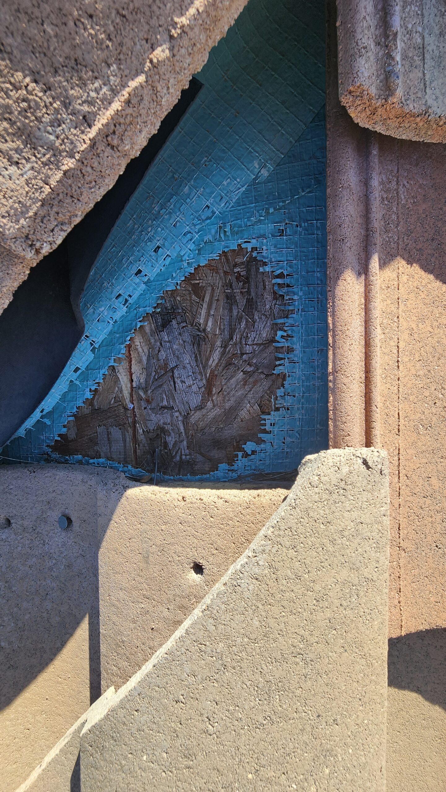 UV degraded tile roof underlayment in Phoenix Arizona showing deterioration beneath displaced tiles
